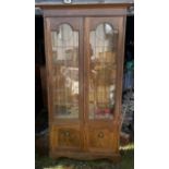 An arts and Crafts attr Liberty glazed cabinet , the twin doors with typical Astral glazed design