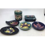 A collection of six Moorcroft pottery to include a lidded jar, a lidded box, and four plates. (6)