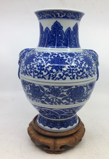 A Chinese blue and white twin-handled Zun vase, height 23.8cm, together with a stand.  Condition
