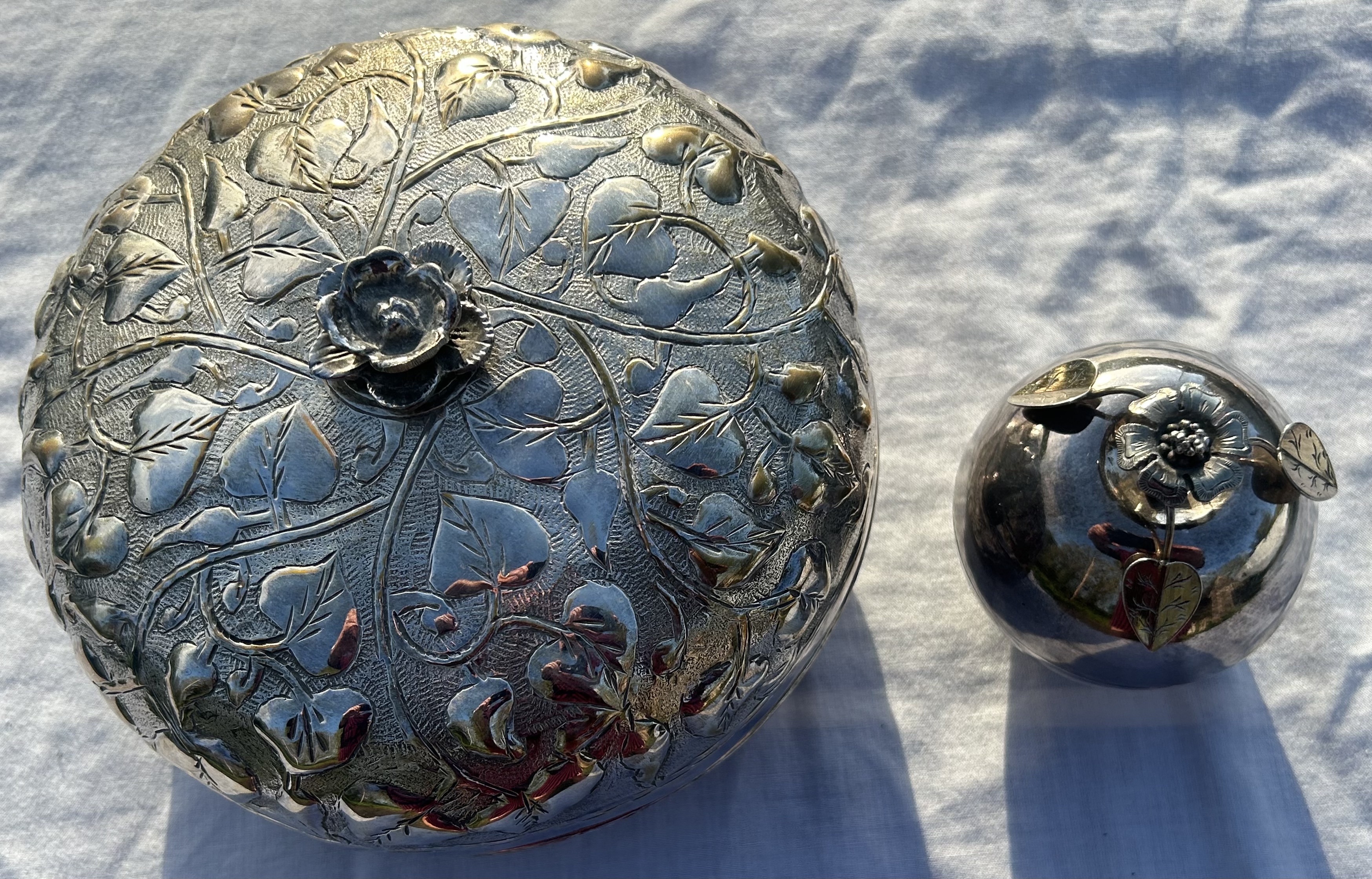 A 20th cent Islamic white metal box and cover and similar smaller Persian silver simulated silver
