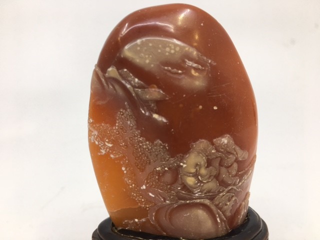A Chinese relief carved orange hardstone, depicting two figures in a boat with prunus tree and - Image 2 of 3