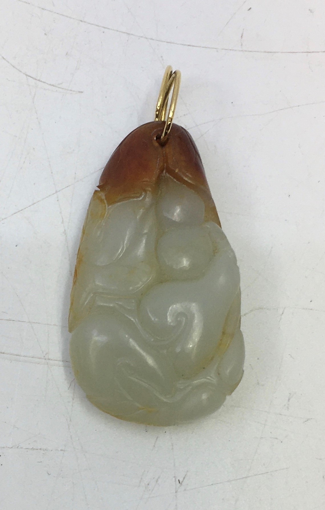 A Chinese carved celadon jade pendant with russet inclusions - Image 2 of 2