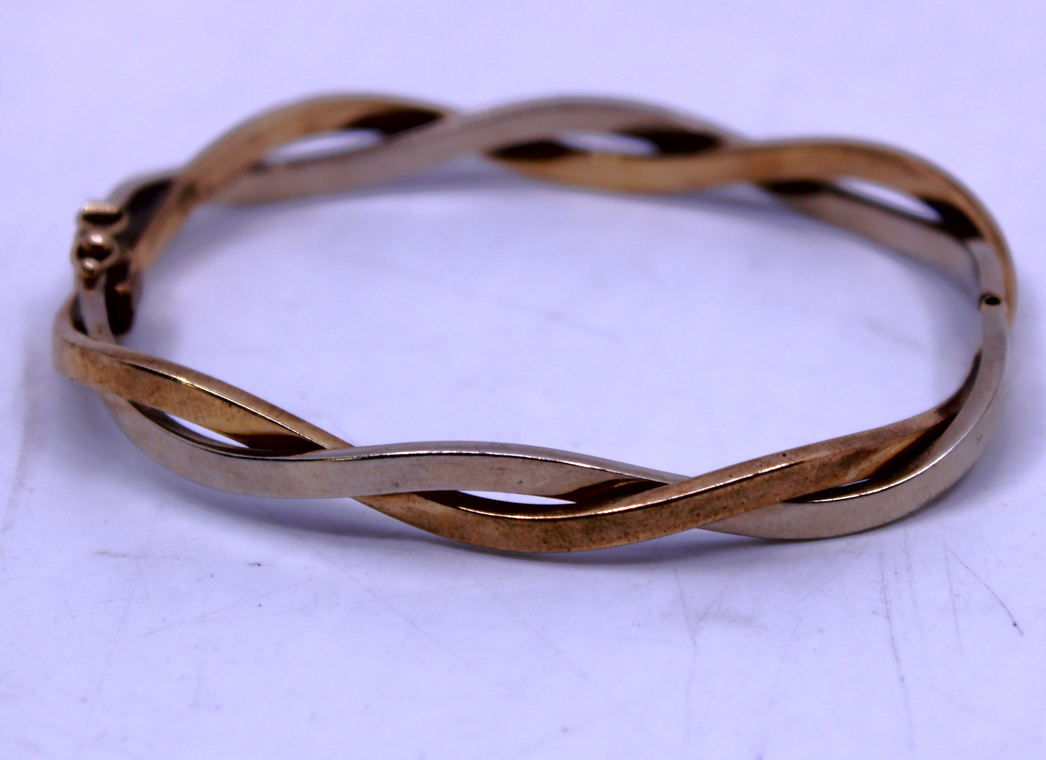 9ct Yellow & White Gold Twist Design Bangle (Hinged).  The Bangle is hallmarked "375" for 9ct Gold.
