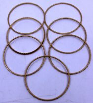 Selection of Seven Unmarked Yellow Metal Patterned Bangles. Total weight is approx. 73.75g.