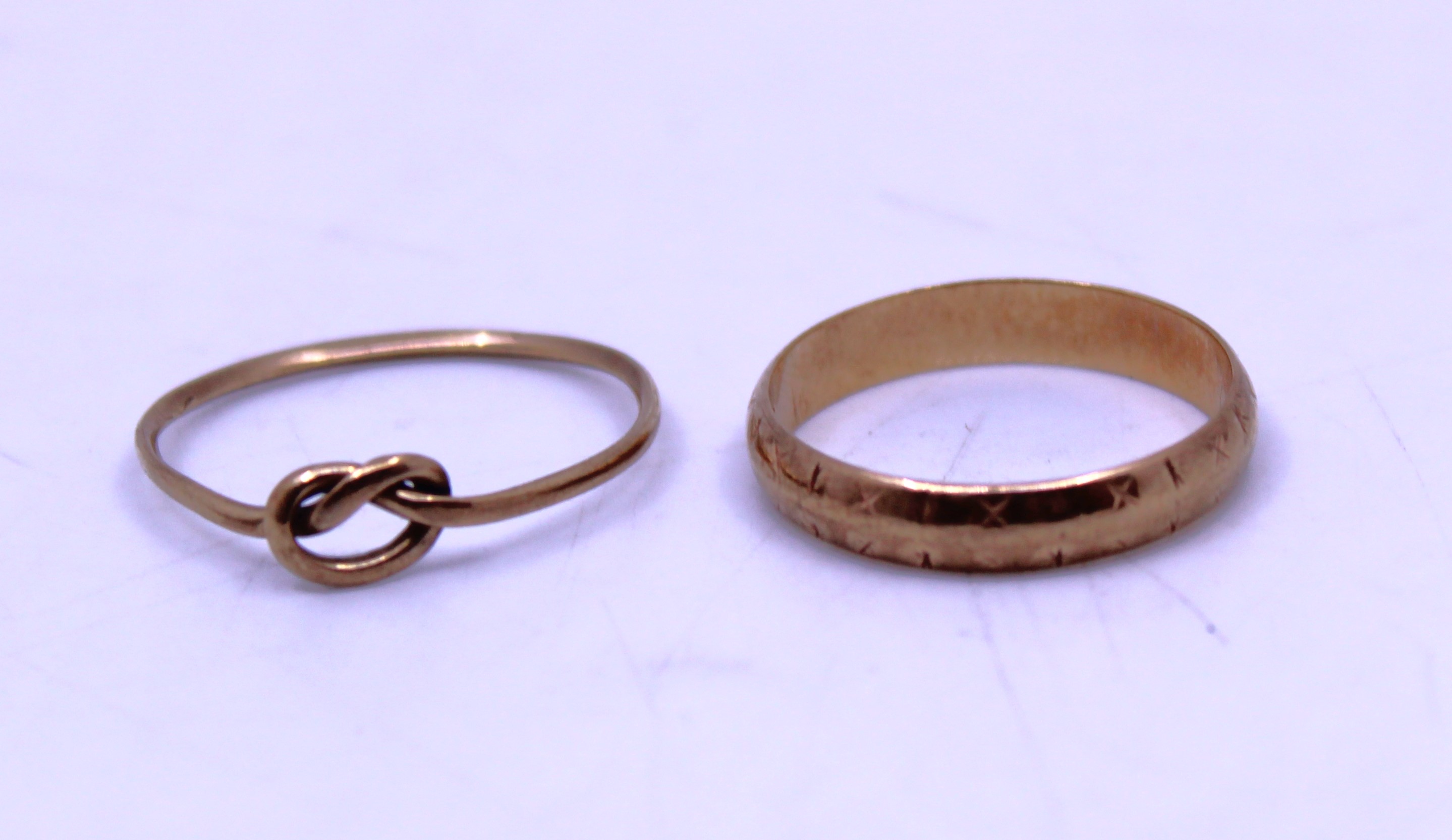 9ct Gold Wedding Band and 9ct Gold Knot Ring.   They are both hallmarked "375" for 9ct Gold.  The