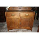 Oak arts and craft style 2 draw 2 door sideboard with brass detailed handles.