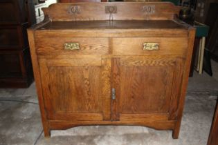 Oak arts and craft style 2 draw 2 door sideboard with brass detailed handles.