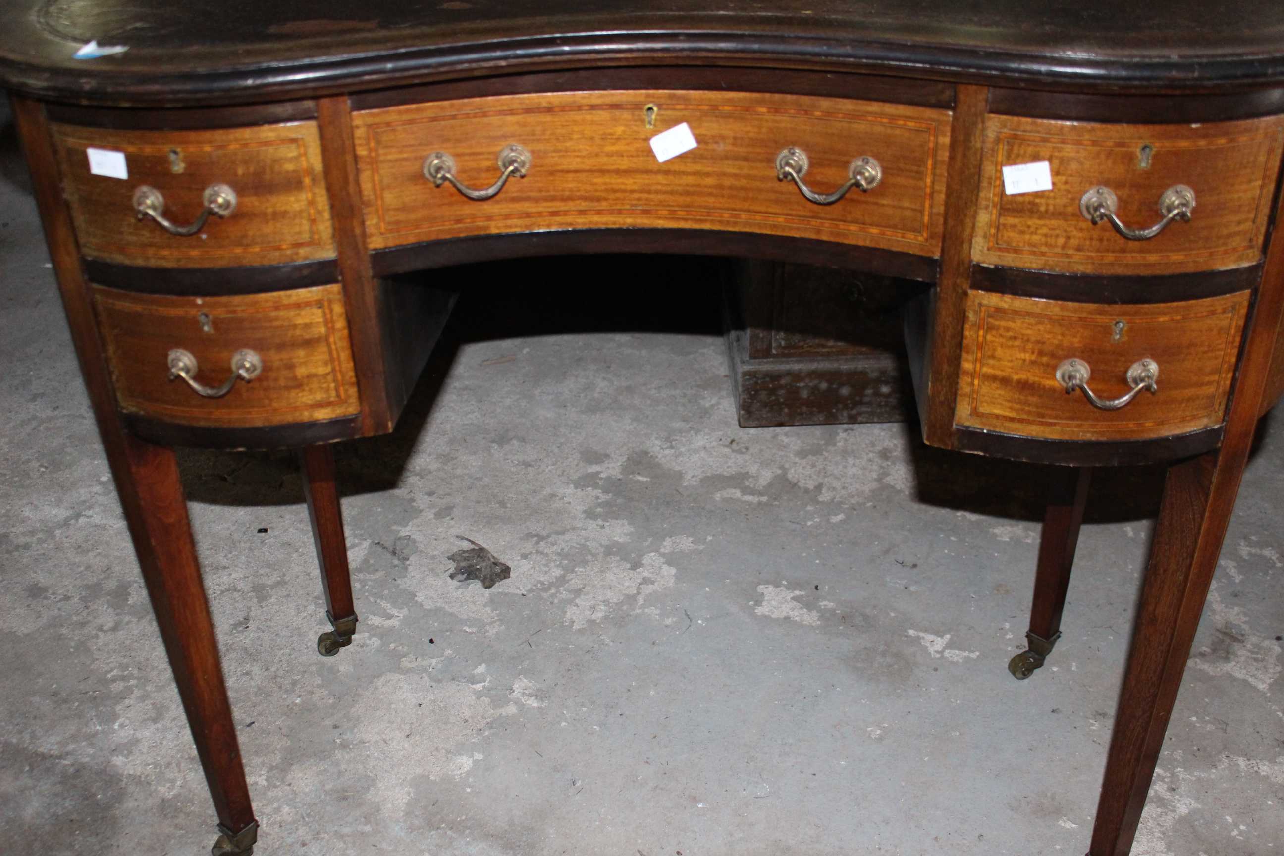 An Edwardian Kidney shape mahogany inlaid desk raised on brass castors. 97cm wide. (1) new leather - Image 3 of 3