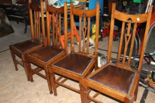 4 x arts and craft style dining chairs with leather padded seats.