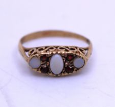 9ct Yellow Gold Opal and Garnet Ring.  The ring contains an Oval Cabochon Opal in the centre that