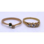 Two Gold Dress Rings. To include an 18ct Yellow Gold White Zircon Three-Stone Ring and a 10k