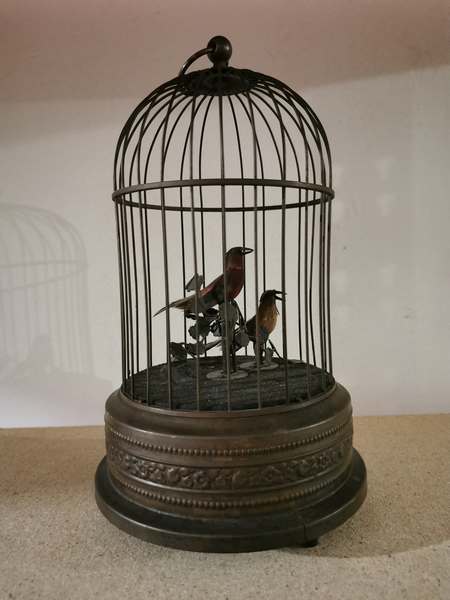Vintage automation birds in a cage. Wind up using the fixed key underneath and listen to the birds