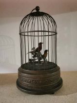 Vintage automation birds in a cage. Wind up using the fixed key underneath and listen to the birds