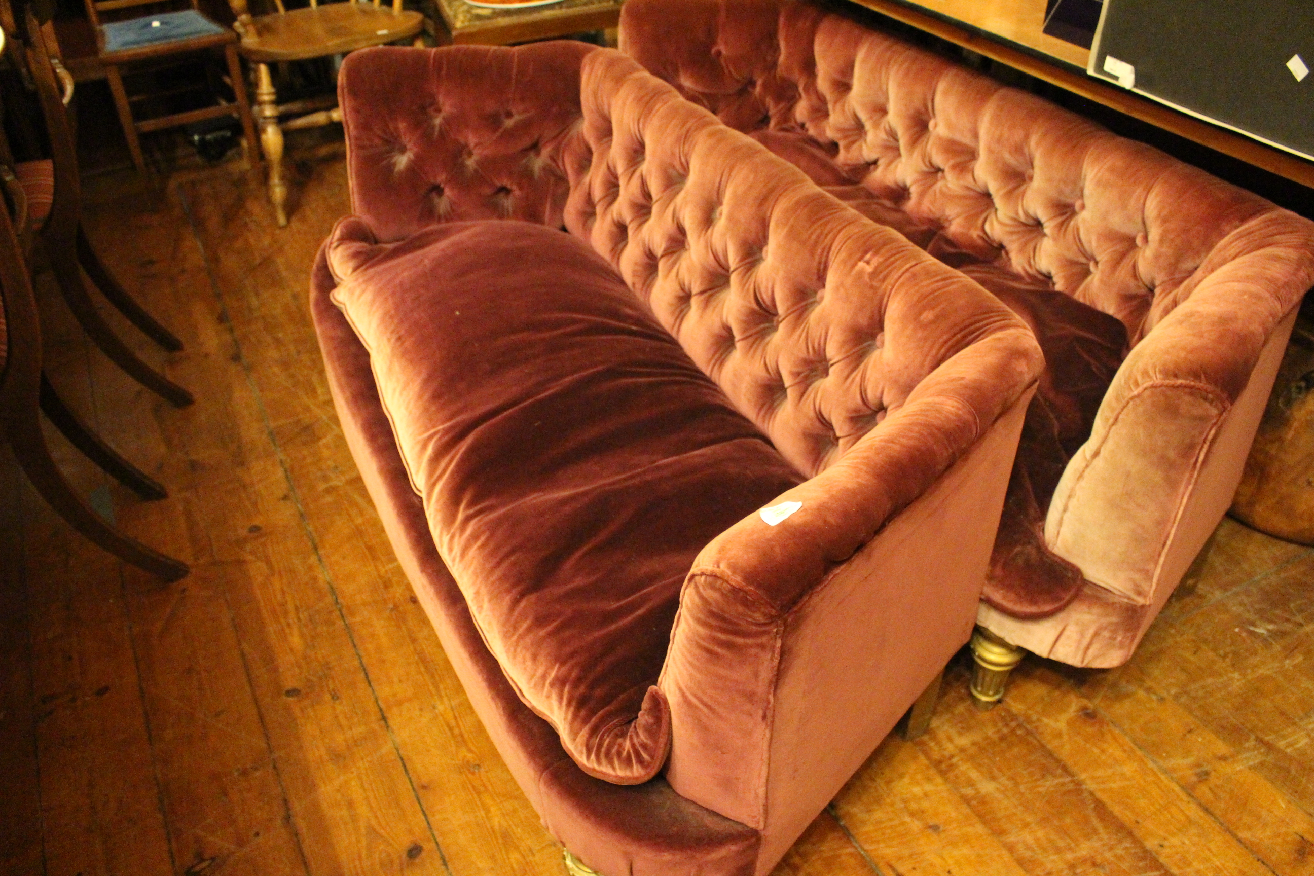 A pair of plum salon boudoir sofas. Deep plum with some sun bleaching to fronts. Plump feather seat