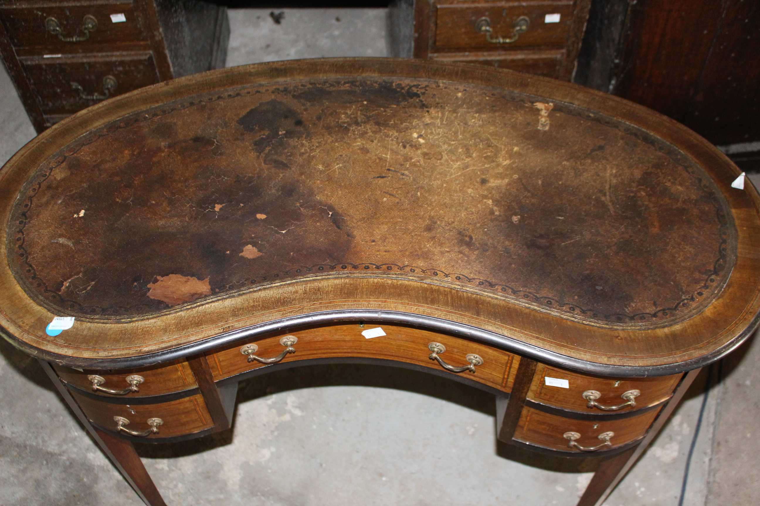 An Edwardian Kidney shape mahogany inlaid desk raised on brass castors. 97cm wide. (1) new leather - Image 2 of 3