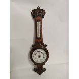 A carved oak cased aneroid barometer circa 1900. 74cm high. In good condition. (1)
