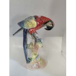 An iridescent painted pottery parrot by Jema of Holland number 819, 41cm high. In good condition.