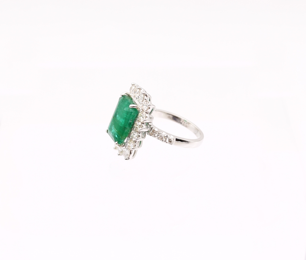 A Zambian emerald and diamond 18ct gold cluster ring, comprising a step-cut emerald (heavily - Image 3 of 7