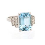 An Art Deco style aquamarine and diamond set 18ct white gold ring, comprising a rectangular step cut