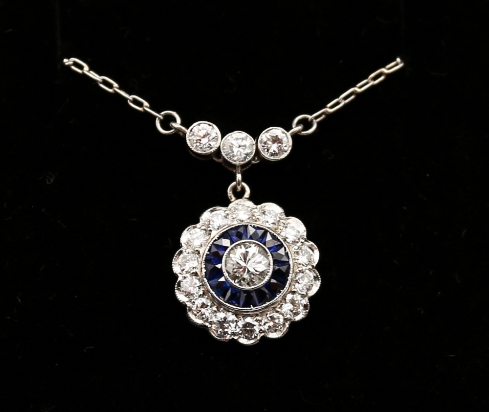 A sapphire and diamond platinum cluster pendant, comprising circular design set to the centre with a