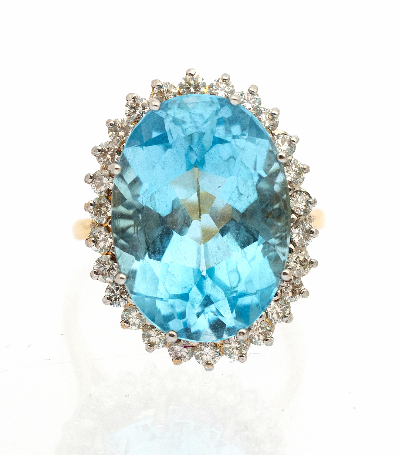 A blue topaz and diamond set 18ct gold cocktail ring, comprising an oval mixed cut blue topaz (Swiss