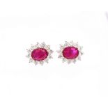 A pair of ruby and diamond set 18ct white gold oval cluster studs, rubies weighing a total of approx