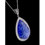 A large tanzanite and diamond set silver pendant, comprising a carved pear shaped tanzanite, total