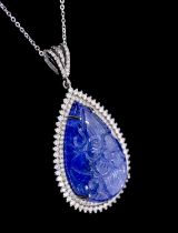 A large tanzanite and diamond set silver pendant, comprising a carved pear shaped tanzanite, total