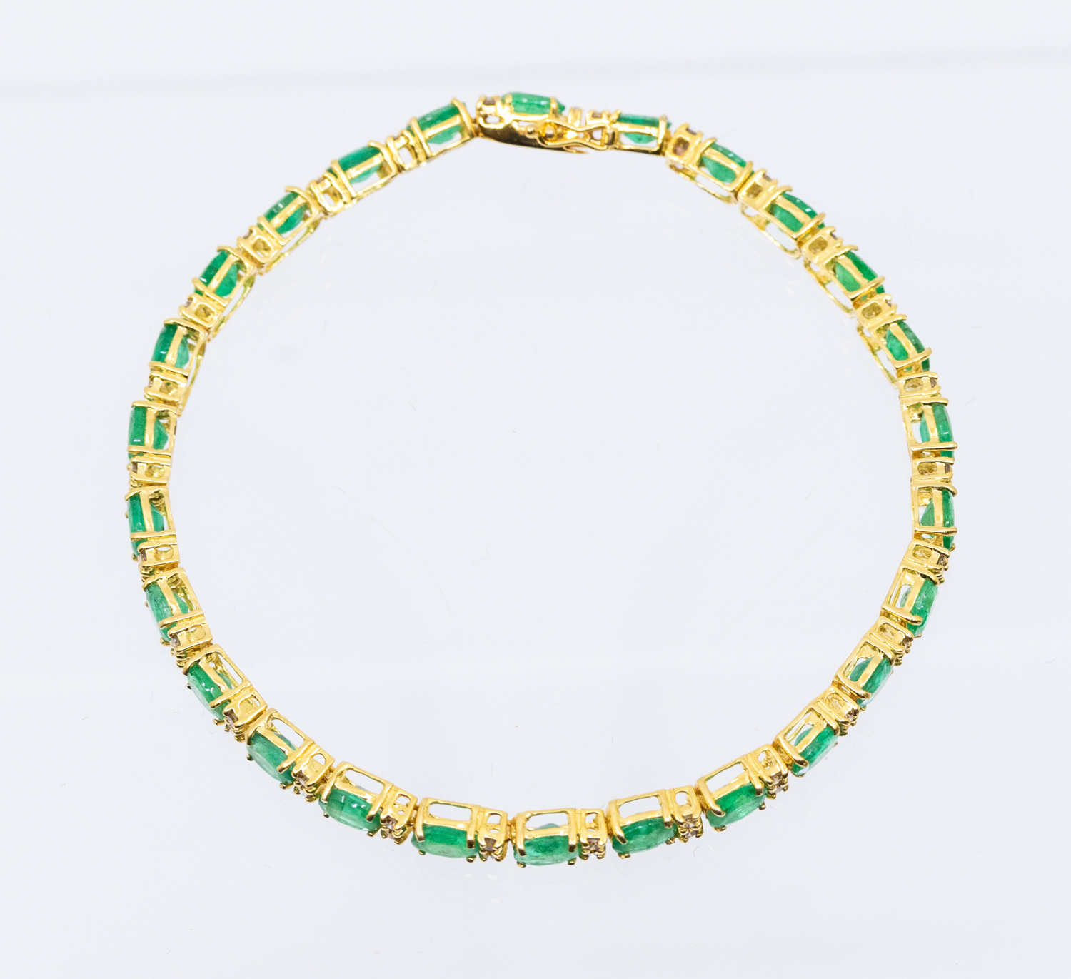 An emerald and diamond 18ct yellow gold tennis bracelet, comprising alternating oval mixed cut - Image 2 of 3