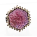 A tourmaline and diamond silver set dress ring, comprising an octagonal carved rubellite tourmaline,