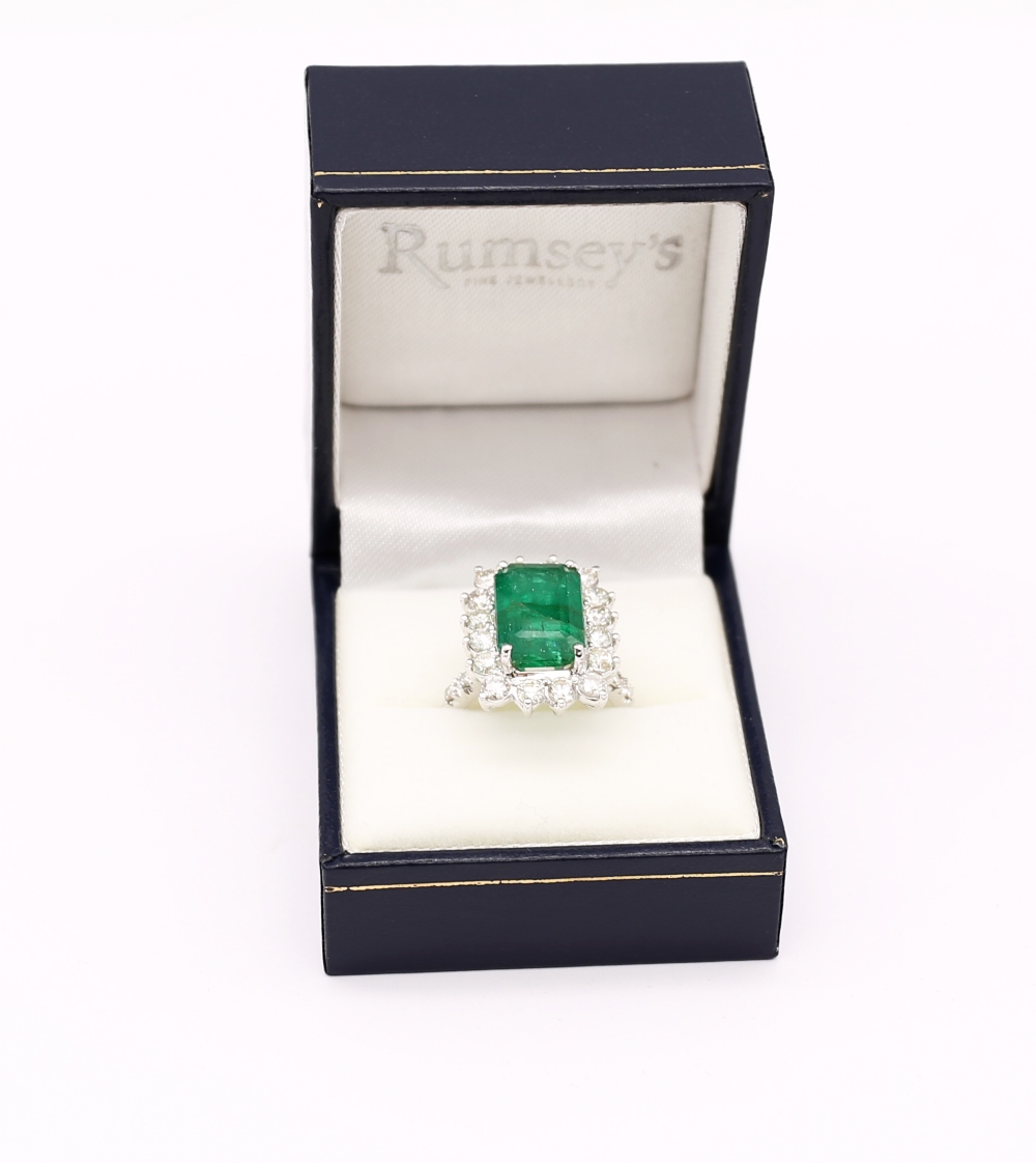 A Zambian emerald and diamond 18ct gold cluster ring, comprising a step-cut emerald (heavily - Image 5 of 7
