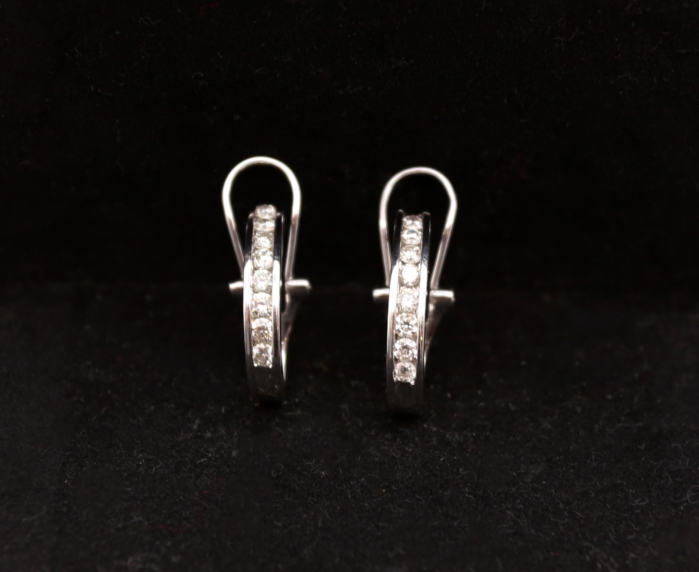 A pair of diamond and 14ct white gold diamond earrings, comprising a row of channel set round