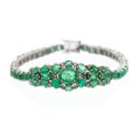 An emerald and diamond set silver bracelet set with oval and pear cut emeralds with diamond set