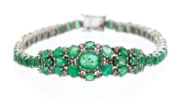 An emerald and diamond set silver bracelet set with oval and pear cut emeralds with diamond set