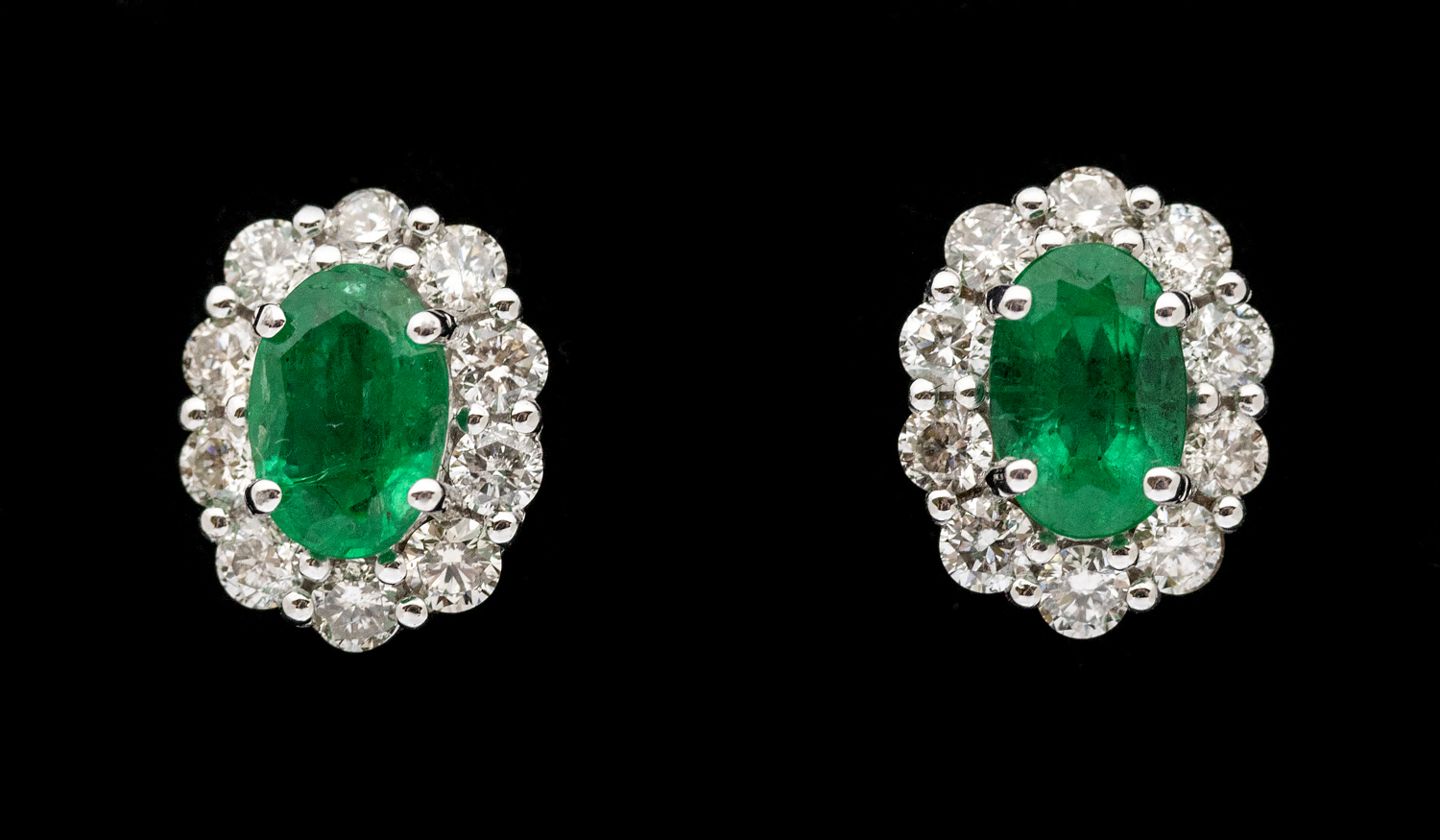 A pair of emerald and diamond 18ct white gold cluster studs, set with oval emeralds, total weight