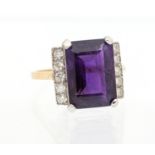 An Art Deco style amethyst and diamond 18ct yellow gold ring, comprising a claw set rectangular step