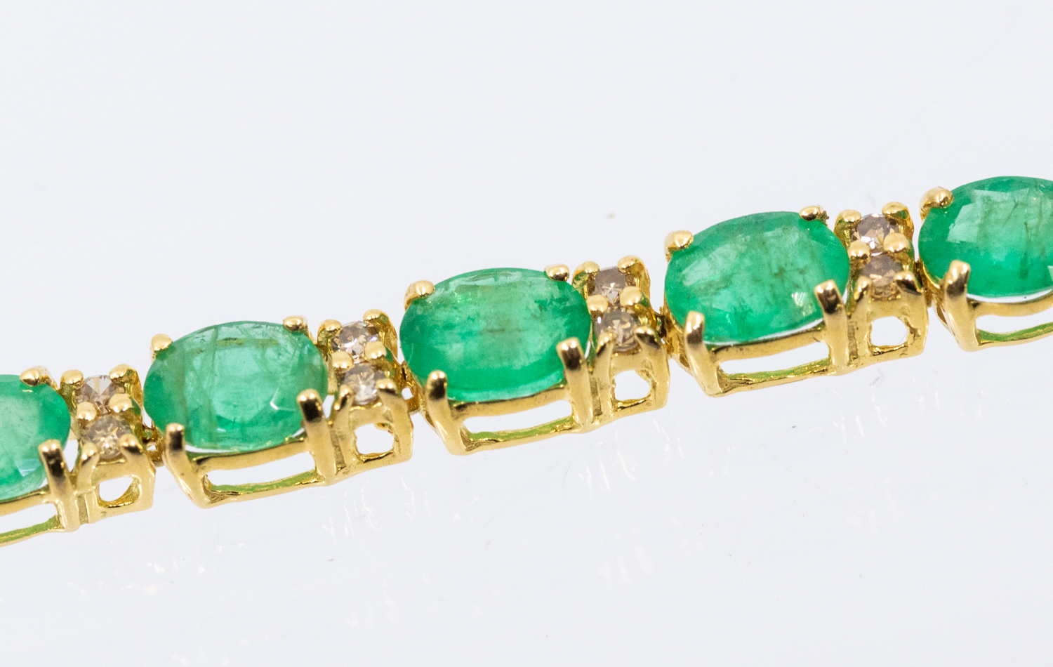 An emerald and diamond 18ct yellow gold tennis bracelet, comprising alternating oval mixed cut - Bild 3 aus 3