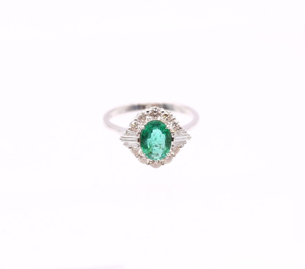 An emerald and diamond 18ct white Art Deco style cluster ring, the central emerald weighing approx