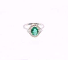 An emerald and diamond 18ct white Art Deco style cluster ring, the central emerald weighing approx