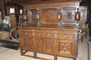 A very large victorian dresser having a raised panel back with the letters J & S carved scroll and