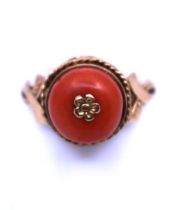 Yellow Metal Coral ring.  It has an Orange Coral Bead in the centre with Gold Flower Decoration.