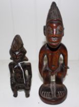 An African wood Yoruba Ibeji male figure, 24.5cm high and an Ibeji female figure, 18cm high  (2)