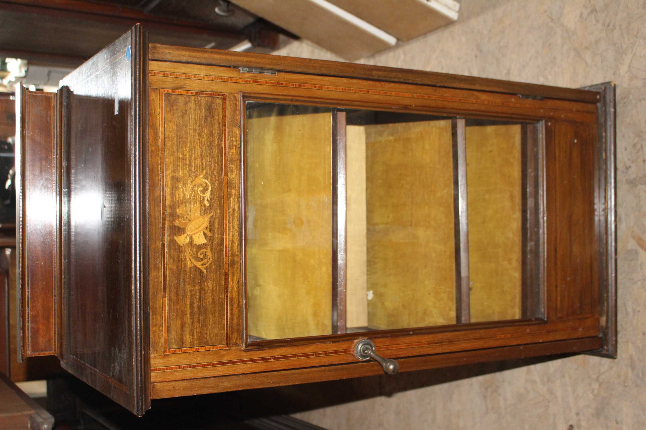 An Edwardian mahogany inlaid, glass fronted music cabinet. (1)