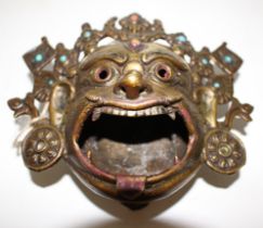 A Tibetan bronze buddha head, 19th/20th century with open mouth, the coronet set with paste