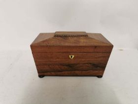 A mid 19th century Rosewood tea caddy raised on bun feet with a brass shield escutcheon. With two