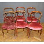 A harlequin set of six Victorian walnut balloon back chairs, raised on cabriole legs.