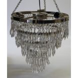 An Eichholtz five tier chrome and lustre drop chandelier