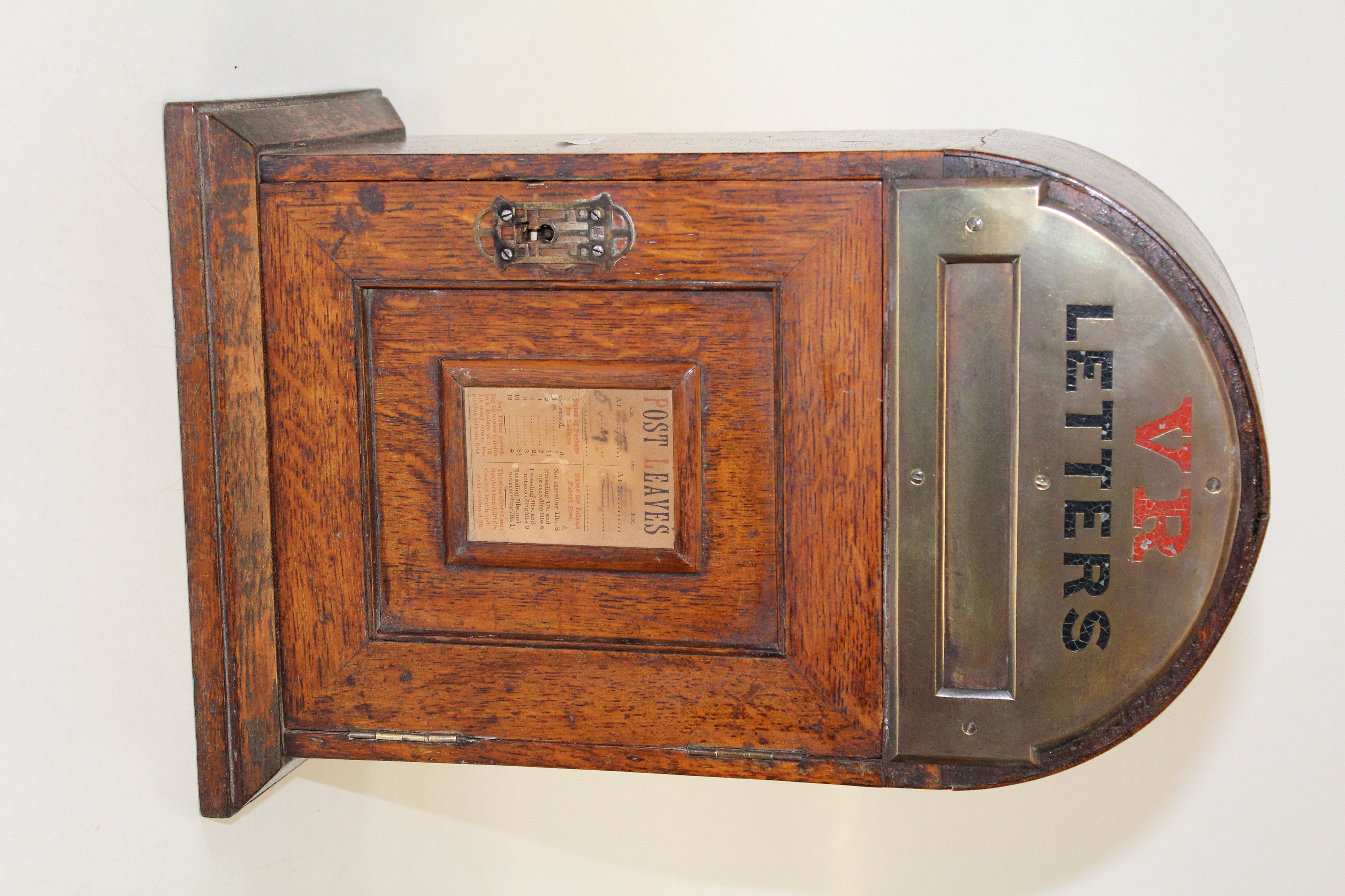 A small Victorian oak Country House letter box of domed form, with brass mount and period paper