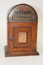 A small Victorian oak Country House letter box of domed form, with brass mount and period paper