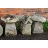 Two weathered stone staddle stones, with caps, together with another staddle stone base with an